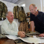 TACTICAL APPROACH: Newport-based Wild Things LLC is currently expanding its military product line for year-round use and is making strides in the consumer market. Above, CEO Edward Schmults, left, and Chief Operating Officer Frank Tarrantino research fabrics for new fire-retardant combat pants. / PBN FILE PHOTO/ KATE WHITNEY LUCEY