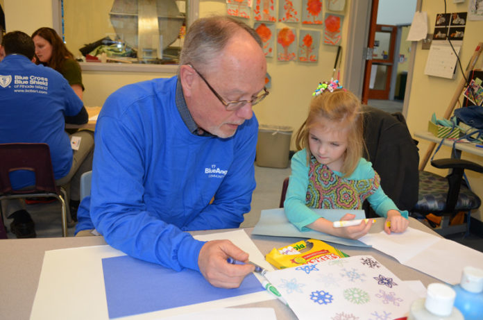 HOLIDAY GIVING: Peter Campbell, from Blue Cross & Blue Shield of Rhode Island’s communications department, volunteers his time at Meeting Street in Providence, working with Georgia, a pre-K student. / COURTESY BCBSRI
