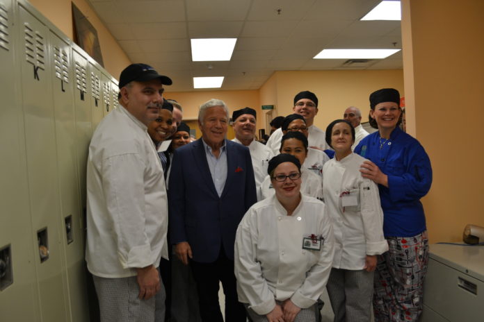 ROBERT KRAFT, Patriots football team owner, center, and chef Heather Langlois, Community Kitchen director, far right, stand with students in Class 55 of the kitchen at the Rhode Island Community Food Bank on Dec. 16. Kraft recently offered a $100,000 challenge grant to the food bank kitchen, which runs a culinary job training program. / COURTESY CINDY ELDER
