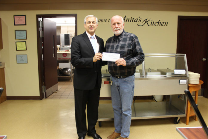DENNIS ALGIERE, senior vice president and director of community affairs at Washington Trust, left, with Russ Partridge, program director of the Westerly WARM shelter, after Partridge accepts a monetary donation to support the pantry.