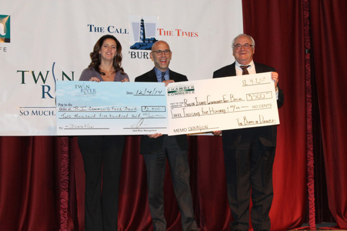 KIM WARD, director of public and community affairs at Twin River, left, and John C. Gregory, president and CEO of the Northern Rhode Island Chamber of Commerce, right, present a $12,000 contribution to Andrew R. Schiff, CEO of the Rhode Island Community Food Bank, during the Chamber’s annual holiday open house at Twin River Casino.