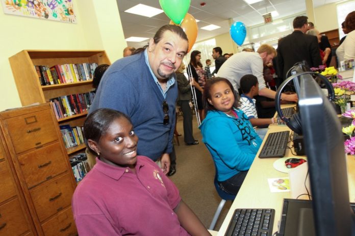PROVIDENCE CITY COUNCILMAN Luis Aponte assists youth patrons of the Washington Park Community Library at the opening of GTECH's After-School Advantage computer lab in this file photo from 2013. Aponte was elected Council President on Tuesday. 