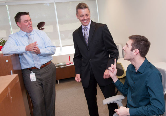 Atrion CEO Tim Hebert, center, is seen talking to Learning & Organizational Development Manager, Jamie Boughman, left, and Intern Ryan Vigneau, right. At a recent meeting with employees, Hebert said that the company plans to grow revenue by 30 percent to reach $145 million in the next 12 months.  / PBN FILE PHOTO/MICHAEL SALERNO