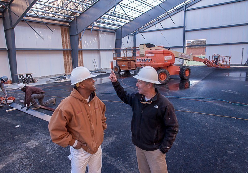 CONTRACT WORK: Jose Marcano, left, president of JM Painting & Plastering, discusses a job at the International Tennis Hall of Fame & Museum with Michael J. Behan Jr., president of Behan Bros. General Contractors and Construction Managers.  Marcano estimates about half of his work comes through sub-work as a Minority Business Enterprise on public contracts.  (The hall of fame project is private work and not subject to MBE regulations.) / PBN PHOTO/MICHAEL SALERNO