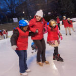 COLD ICE, WARM HEART: Carolyn Drumm, executive director of nonprofit Skate For Joy, helps Andreina Dominguez, left, and Namrita Riat out onto the ice at the Alex and Ani City Center skating rink at Kennedy Plaza in Providence. / PBN PHOTO/MICHAEL SALERNO