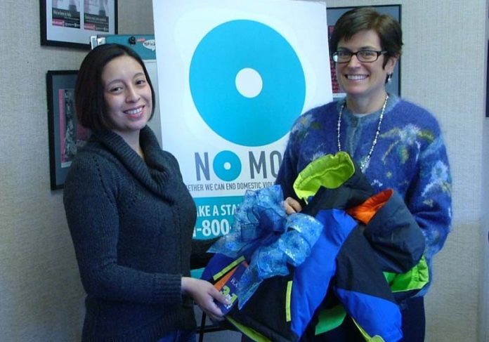 FROM LEFT: Sabrina Solares-Hand, event director for the Savory Affair Event Planning and Design, presents donated coats to Deborah DeBare, executive director of the Rhode Island Coalition Against Domestic Violence. The coats were donated during the holiday open house of sister company The Savory Grape.