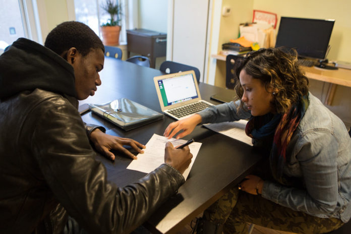 THE NEXT STEP: High school senior Cheikh Gaye works with College Visions adviser Gleyribel Rodriguez on filling out financial aid forms. College Visions has been chosen by Bank of America to receive a $200,000 grant spread out over the next two years. / PBN PHOTO/RUPERT WHITELEY