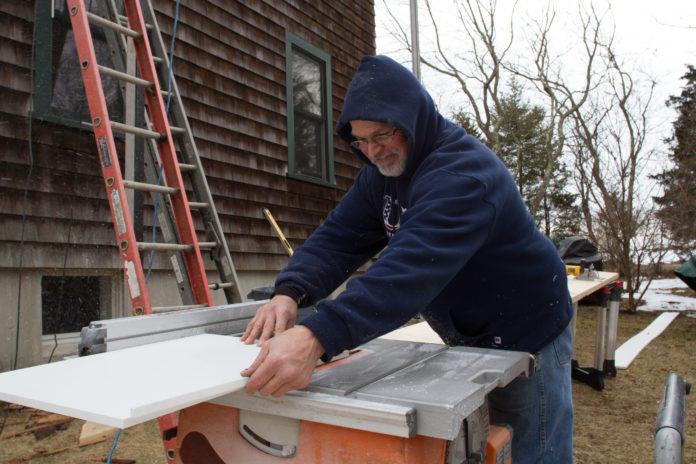 RHODE ISLAND ADDED 200 jobs in February compared with the prior year period, according to data from Associated general Contractors of America. Above, Mike Rothermal of Caldwell and Johnson Custom Builders, cuts trim on a construction site in Jamestown. / PBN FILE PHOTO/KATE WHITNEY LUCEY