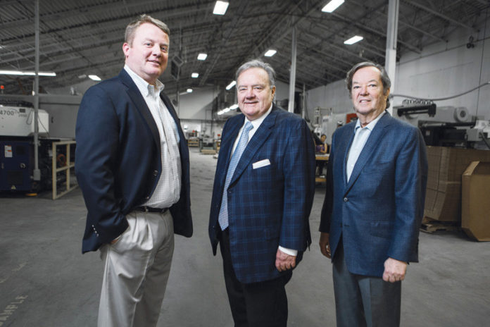 SMART INVESTMENT: Since President and CEO Thomas Melucci, center, and Richard Bready, right, bought Hope Valley Industries out of bankruptcy in 2002, the company has made a mark on the global automobile market, becoming recognized by both Ford and GM for the quality of its floor mats, produced under the guidance of Executive Vice President Craig Melucci. / PBN PHOTO/RUPERT WHITELEY
