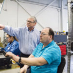 IN SEARCH OF THE EDGE: Lean manufacturing and use of Kaizen principles have helped Hayward Industries prosper on a global scale. Pictured are technicians Joseph Veillette, right, and Chanouch Soeum with Hayward Industries Continuous Improvement Manager Gregory Fowler, standing. / PBN PHOTO/RUPERT WHITELEY