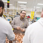 LOCKING IN PROGRESS: Quick Fitting Vice President of Engineering Libardo Ochoa, center, knows that innovation comes from all members of the organization, including workers on the floor. / PBN PHOTO/RUPERT WHITELEY