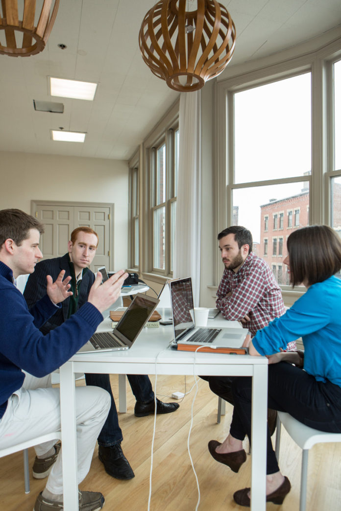 From left to right, CallRed co-founder Daniel Reilly and founder and CEO Andrew Kelley sit with Adam Croft and Sarah Cowan Johnson, of Intervarsity. / PBN PHOTO/RUPERT WHITELEY