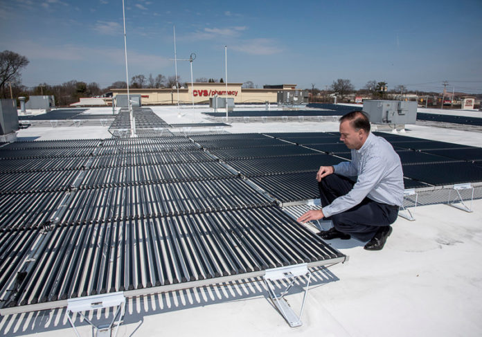 BRIGHT IDEA: Christopher Morra Sr., president and CEO of National Security, shows off a solar panel system that he said in 2014 had saved the company $8,631 in 13 months. / PBN FILE PHOTO/MICHAEL SALERNO