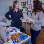 RAY OF HOPE: Loren Hope Designs LLC founder and Creative Director Loren Barham, left, and assistant Maggie Ferri examine glass for new designs. / PBN PHOTO/?MICHAEL SALERNO