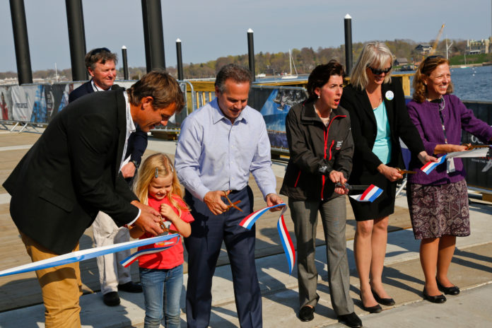 FROM LEFT, Volvo Ocean Race CEO Knut Frostad, his daughter Pernilla, Congressman David N. Cicilline, Gov. Gina M. Raimondo, R.I. DEM Director Janet Coit, and state Senate President M. Teresa Paiva Weed cut the ribbon to the new North Pier at Fort Adams during the opening ceremony for the Volvo Ocean Race Newport Race Village last week. In the background is Sail Newport Executive Director Brad Read. / COURTESY DAN NERNEY/SAIL NEWPORT/VOLVO OCEAN RACE NEWPORT