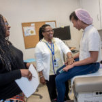 Can neighborhood health stations help curb costs? LOCAL TREATMENT: Vanessa Semedo, right, a senior at Central Falls High School, at the school's health clinic with Sara Perry, left, Central Falls practice manager for Blackstone Valley Community Health Care, and LeTotha Wiggins, medical assistant. / PBN PHOTO/MICHAEL SALERNO