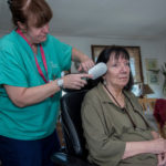 AT HOME: Jennifer Fonner, left, CNA with South County Quality Care, works with patient Janet Beauvais in Beauvais' Narragansett home. / PBN PHOTO/MICHAEL SALERNO