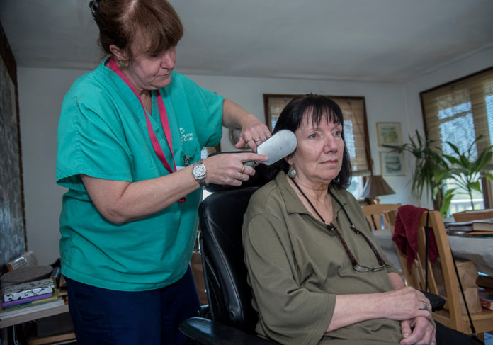 AT HOME: Jennifer Fonner, left, CNA with South County Quality Care, works with patient Janet Beauvais in Beauvais' Narragansett home. / PBN PHOTO/MICHAEL SALERNO