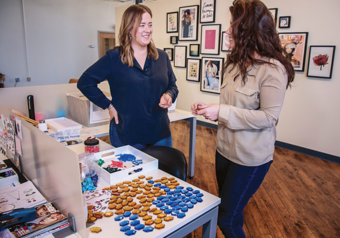 RAY OF HOPE: Loren Hope Designs LLC founder and Creative Director Loren Barham, left, and assistant Maggie Ferri examine glass for new designs. / PBN FILE PHOTO/MICHAEL SALERNO