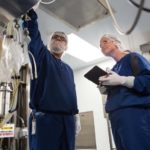 Pride in product quality, staff WORKING TOGETHER: A multinational corporation, Amgen Inc. promotes collaboration among its employees, including its 640 in West Warwick. Above, senior manufacturing associates Erik Claros and Michelle Dorgan at Amgen Inc. complete a steaming operation of the sample line of a bioreactor. / PBN PHOTO/RUPERT WHITELEY