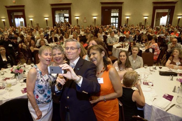 COMMUNICATING FUN: Amica Chairman, President and CEO Robert A. DiMuccio attempts a group selfie at the company's annual dinner, an event that honors recent retirees and 25th anniversary employees. / COURTESY AMICA