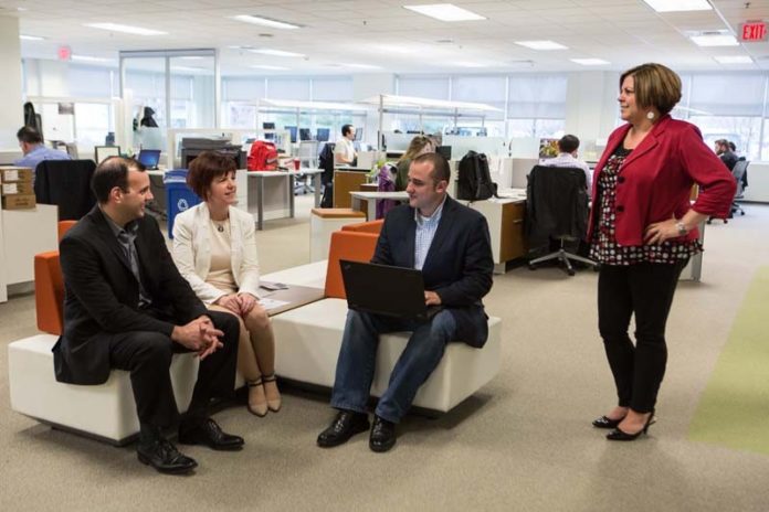 OPEN IMPACT: Atrion's open floor plan allows for impromptu meetings. Here, from left, are Peter Abreu, Marianne Caserta, Jason Albuquerque and Sherri Araujo. / PBN FILE PHOTO / RUPERT WHITELEY