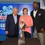 PATRIOTS CHAIRMAN AND CEO Robert Kraft, left, and Patriots and Pro Football Hall of Famer Andre Tippett congratulate Rebecca Moniz of East Greenwich, R.I., of the Realtor Foundation Rhode Island for being selected as a 2015 Myra Kraft Community MVP Award third prize winner. During a recent luncheon, the Kraft family and the New England Patriots Charitable Foundation awarded $200,000 in grants to 26 New England nonprofits.