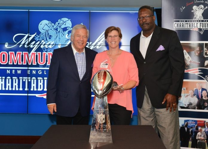 PATRIOTS CHAIRMAN AND CEO Robert Kraft, left, and Patriots and Pro Football Hall of Famer Andre Tippett congratulate Rebecca Moniz of East Greenwich, R.I., of the Realtor Foundation Rhode Island for being selected as a 2015 Myra Kraft Community MVP Award third prize winner. During a recent luncheon, the Kraft family and the New England Patriots Charitable Foundation awarded $200,000 in grants to 26 New England nonprofits.