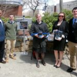 FOUR URI engineering students won first place in the University Design Competition for Addressing Airport Needs, sponsored by the Federal Aviation Administration, for inventing a drone detection system. From left to right, Alan Andrade, vice president of the Rhode Island Airport Corporation, and students Stephen Pratt, Catherine LiVolsi, Krista Brouwer and Thomas Cottam. LiVolsi is holding a drone, and Brouwer is holding the drone detection system that they invented.