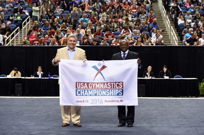 FROM LEFT to right, John Gibbons, executive director of the R.I. Sports Commission receives the ceremonial flag from USA Gymnastics Chief Operating Officer Ron Galimore at the recent 2015 Championships held in Greensboro, N.C. Providence has been chosen to host the 2016 USA Gymnastics Championships.

 / COURTESY PROVIDENCE WARWICK CONVENTION & VISITORS BUREAU