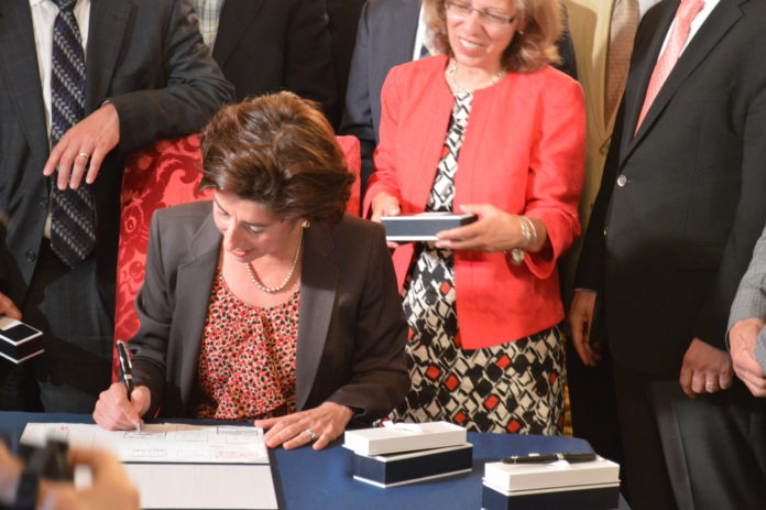 GOV. GINA M. RAIMONDO IS shown signing her first state budget on Tuesday. / COURTESY GOVERNOR'S OFFICE