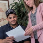 ADMIRABLE WORK: Amed Cepeda, laminating associate for Admiral Packaging, reviews testing documents for a National Career Readiness Certificate with Colleen Bernier, recruiter with the company. / PBN PHOTO/MICHAEL SALERNO