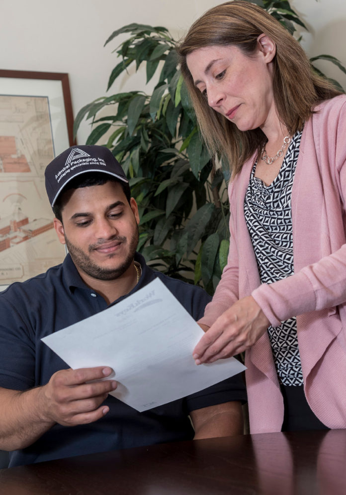 ADMIRABLE WORK: Amed Cepeda, laminating associate for Admiral Packaging, reviews testing documents for a National Career Readiness Certificate with Colleen Bernier, recruiter with the company. / PBN PHOTO/MICHAEL SALERNO