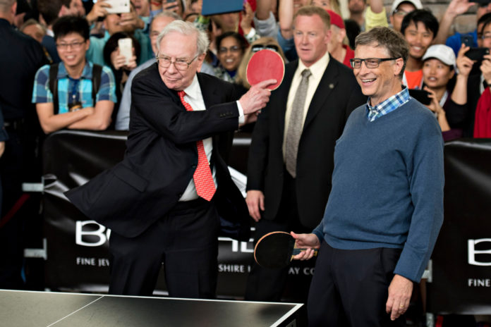 WARREN BUFFETT, chairman of Berkshire Hathaway, left, plays ping pong with Bill Gates, chairman and founder of Microsoft and a Berkshire Hathaway director, during a shareholder event at the Berkshire Hathaway annual shareholders meeting in Omaha, Neb., on Sunday, May 3, 2015. Buffett has praised Gates and his wife Melinda for not only pledging money for philanthropic purposes but for contributing their time and energy to efforts designed to solve a number of global challenges. / BLOOMBERG NEWS FILE PHOTO/DANIEL ACKER