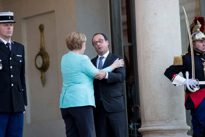 FRANCOIS HOLLANDE, France's president, right, embraces Angela Merkel, Germany's chancellor, as she departs Elysee Palace following a meeting in Paris on Monday. Merkel said 