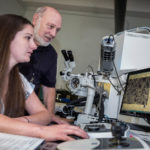 Colleges put research tools within reach WIDE SCOPE: Christine Cook, engineer and analytical chemistry lab lead in research development at the Yardney division of EaglePicher Technologies, works with Everett E. Crisman, retired URI chemical engineering professor, on the Zeiss Field Emission Scanning Electron Microscope. / PBN PHOTO/ MICHAEL SALERNO