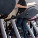 TAKING CHARGE: IGT employees have driven the company's wellness initiatives over the years, including getting well-equipped workout rooms in company facilities. Here Russell Lavoie, an intern who is a student at Rhode Island College, uses a treadmill at the company's Providence offices. / PBN PHOTO/MICHAEL SALERNO