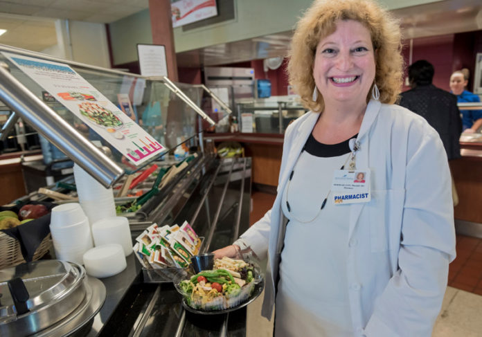 MAKING HEALTH A PRIORITY: South County Health looks to improve the health and wellbeing of employees as well as patients, offering, among other things, healthy food choices at the on-site dining room, including pharmacist Deborah Cote's choice, a 310-calorie Southwestern grilled chicken salad. / PBN PHOTO/MICHAEL SALERNO