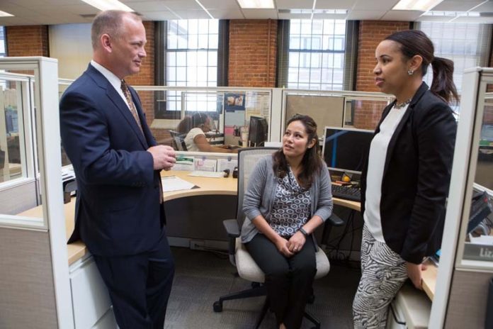 GOOD NEIGHBORS: Neighborhood Health Plan of Rhode Island saw its revenue jump in 2014 to $829.6 million from $427.6 million in 2012. Above, CEO Peter Marino speaks with Telma Gonzalez, center, and Lizzy Lima. / PBN PHOTO/RUPERT WHITELEY