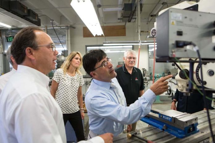 WELL-OILED MACHINE: Professor Bahram Nassersharrif, pointing, shows off URI's Wales Hall machine shop to Amtrol employees, from left: Vice President Chris Van Haaren, graphic designer Lisa Lamothe and Associated Product Manager Peter Silverman. / PBN PHOTO/RUPERT WHITELEY