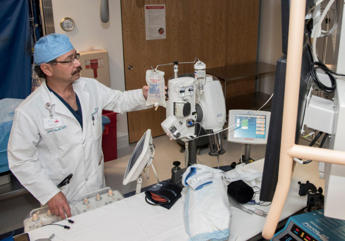 HEARTFELT: Dr. Steven Fera, cardiologist at South County Hospital, checks equipment inside the Cardiac Catherization Lab. / PBN PHOTO/ MICHAEL SALERNO