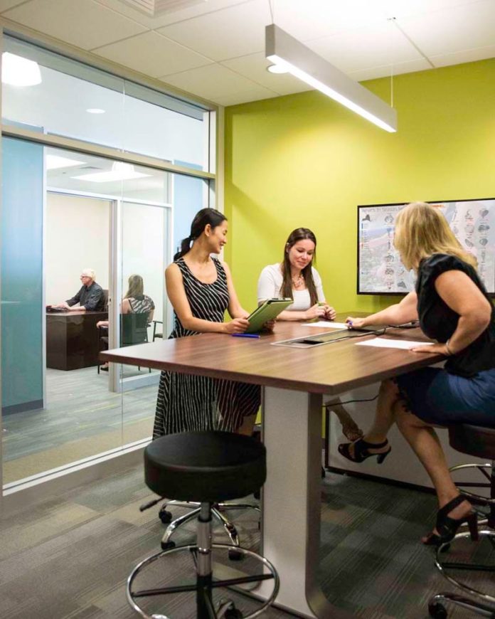 GROUP SESSIONS: A flat-screen monitor, mounted on the wall at right, and standing-height tables allow groups to plug in laptops or tablets.