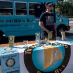 Craft beer: Flavor of the month or growth industry? DRINK LOCAL: Josh Roy, driver for Rhode Island Brew Bus, looks to drum up business at the recent Ocean State Beer Festival. The bus offers weekend tours of local breweries. / PBN PHOTO/MICHAEL SALERNO