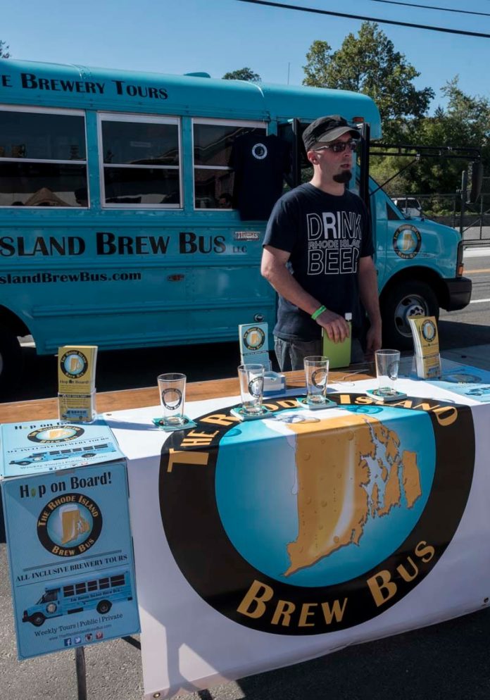 DRINK LOCAL: Josh Roy, driver for Rhode Island Brew Bus, looks to drum up business at the recent Ocean State Beer Festival. The bus offers weekend tours of local breweries. / PBN PHOTO/MICHAEL SALERNO