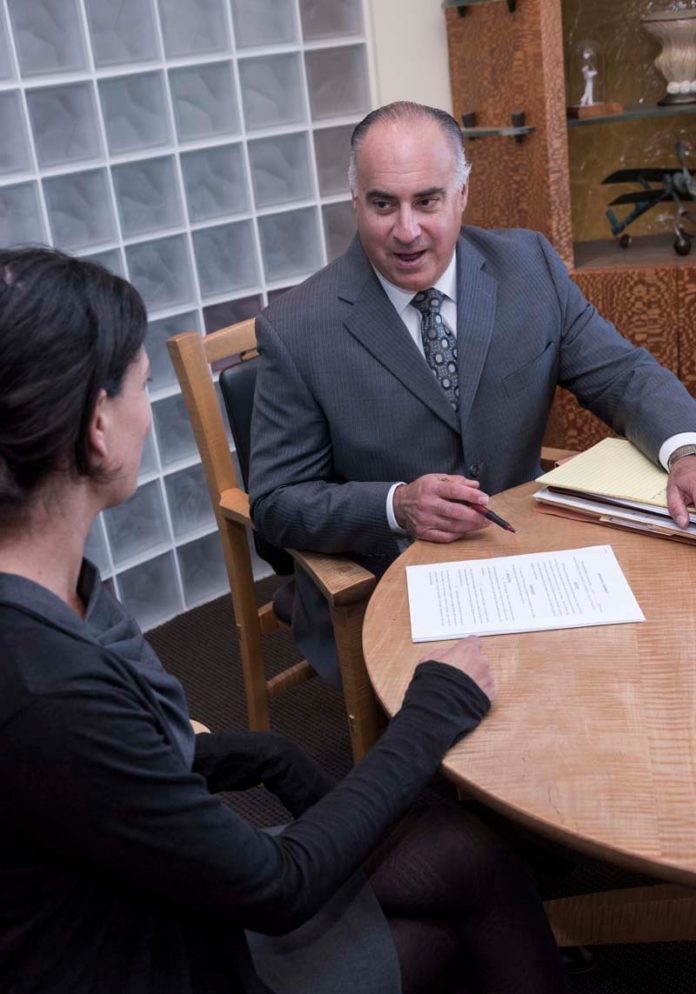 BIG PLANS: Attorney John M. Harpootian of Paster & Harpootian Ltd., meets with associate attorney Jennifer Klein Ericsson. Harpootian specializes in personal and financial planning, and trust and estate administration. / PBN PHOTO/MICHAEL SALERNO