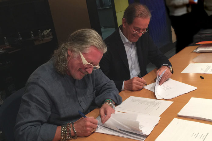 JOHN HAZEN White Jr.,  CEO and chairman of the board of Taco Group, and Elio Marioni, Askoll's founder and president, sign sale documents in Dueville, Italy. / COURTESY TACO GROUP