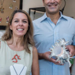 NATURAL BEAUTY: Simona and Alessandro Cataldo, owners of Jewels of the Seas on Goddard Row in Newport. display two pieces sold at their store. Simona holds a carved natural coral and 18K gold pendant. Alessandro holds the shell Murex Ramosus covered in silver. / PBN PHOTO/ MICHAEL SALERNO