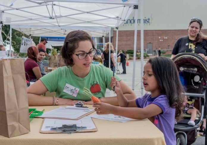 FOOD FOR THOUGHT: Mikayla Anthes, Farm Fresh Rhode Island healthy foods/healthy families coordinator, and Raven Horn of Woonsocket, talk at a recent Thundermist Health Center event. / PBN FILE PHOTO/MICHAEL SALERNO