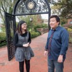 CULTURAL EXCHANGE: Bryant seniors Leiyan Li, left, and Jiwei "Vince" Ma, both from China, in front of the university's archway in Smithfield. / PBN PHOTO/MICHAEL SALERNO