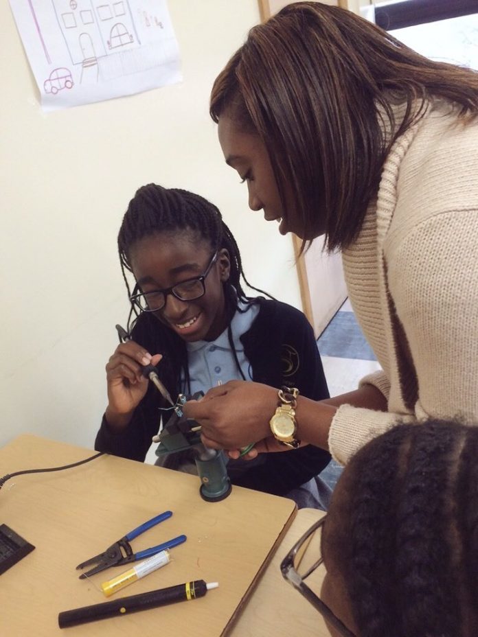 A MIDDLE SCHOOL STUDENT from Sophia Academy in Providence works with a volunteer during a workshop at the recent STEM in the Middle career expo for middle school girls held at Rhode Island College's STEM Center. / COURTESY TECH COLLECTIVE